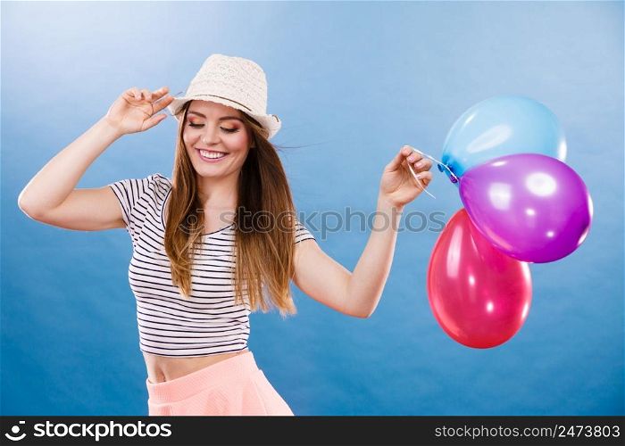 Woman attractive joyful girl playing with colorful balloons. Summer holidays, celebration and lifestyle concept. Studio shot blue background . Woman summer joyful girl with colorful balloons