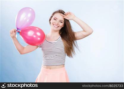 Woman attractive joyful girl playing with colorful balloons. Summer holidays, celebration and lifestyle concept. Studio shot blue background