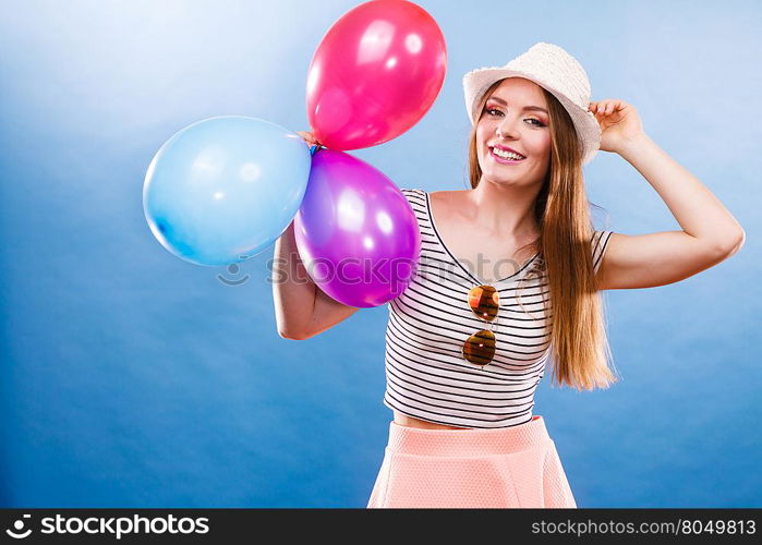 Woman attractive joyful girl playing with colorful balloons. Summer holidays, celebration and lifestyle concept. Studio shot blue background