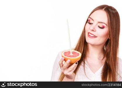 Woman attractive long hair girl colorful eyes makeup holding grapefruit citrus drinking juice from fruit. Healthy diet food. Summer vacation holidays concept. Copy space for text. Woman holds grapefruit drinking juice from fruit