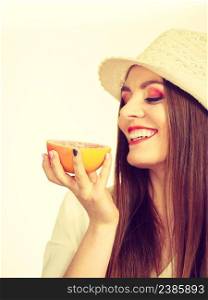 Woman attractive long hair girl colorful eyes makeup holding half of grapefruit citrus fruit in hand. Healthy diet food. Summer holidays fun concept. Woman holding half of grapefruit citrus fruit in hand