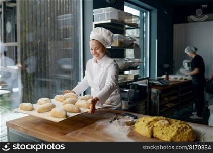 Woman baker engaged in making of traditional yeast buns with cheese. A woman baker making of traditional yeast buns with cheese