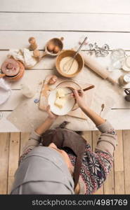 Woman baking Christmas cookies in her kitchen. Top view