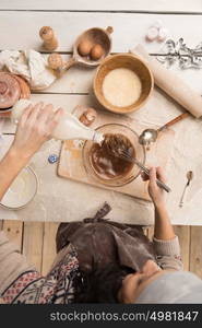 Woman baking Christmas cookies in her kitchen. Top view