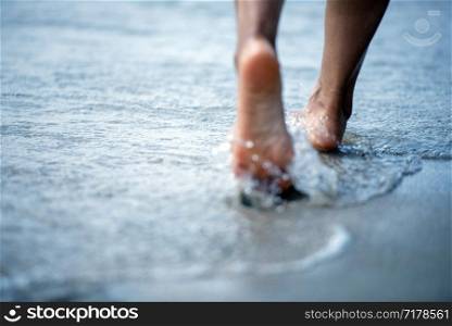 Woman barefoot walking on the beach