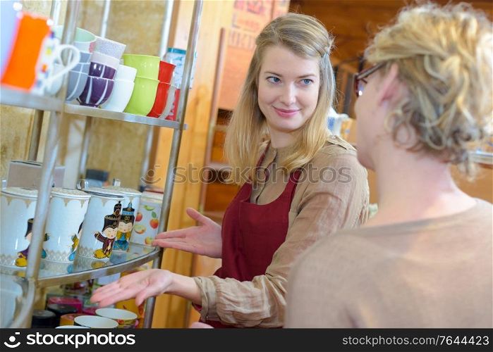 woman being assisted to choose cup in a shop