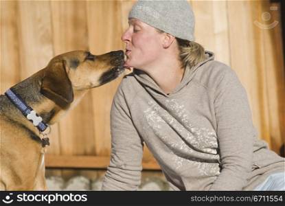 Woman being licked by a dog