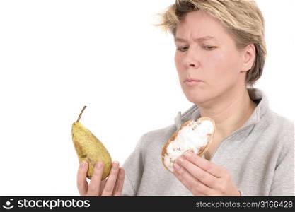 Woman being tempted to take the not to healthy bun or the fruit
