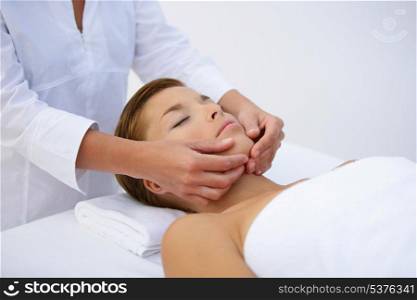Woman being treated to face massage