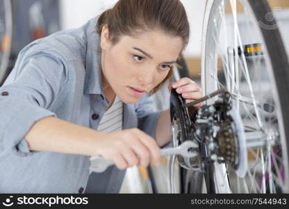 woman bicycle engineer is repairing a bike in the workshop