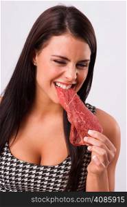 Woman bites into red steak meat