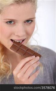 Woman biting a piece of chocolate