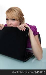 Woman biting laptop