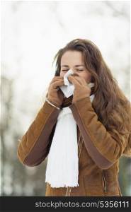 Woman blowing nose in winter outdoors