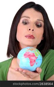 Woman blowing on a globe