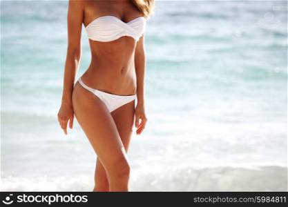 Woman body on beach background. Sexy woman body in bikini on the beach background