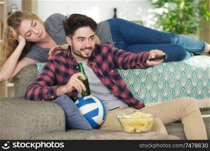 woman bored because her man is watching sport on tv