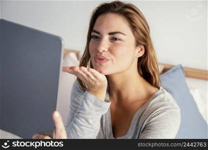 woman bow kiss towards video call tablet 2
