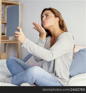 woman bow kiss towards video call tablet