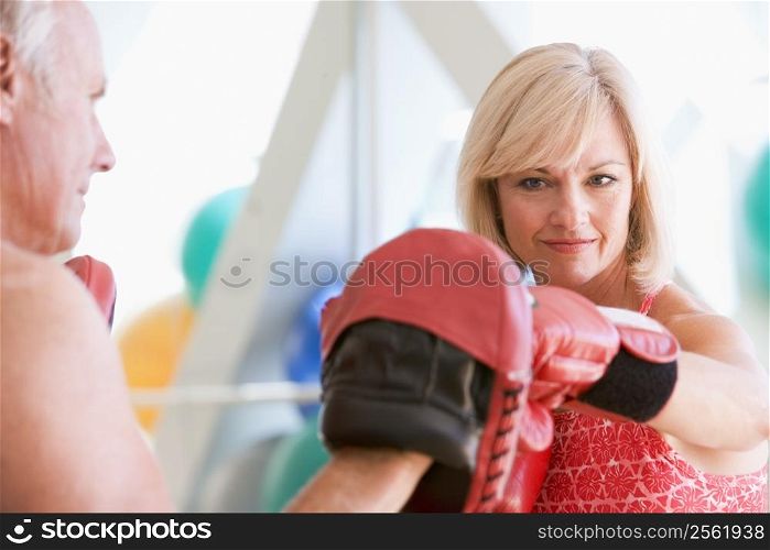 Woman Boxing With Personal Trainer At Gym