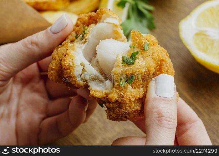 woman breaking piece from fish chips dish. High resolution photo. woman breaking piece from fish chips dish