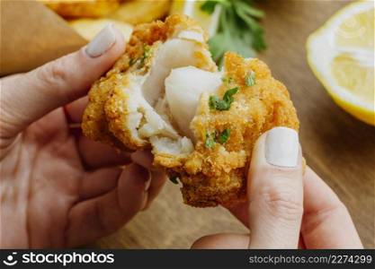 woman breaking piece from fish chips dish. High resolution photo. woman breaking piece from fish chips dish