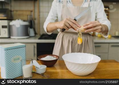 woman breaks egg making pie kitchen