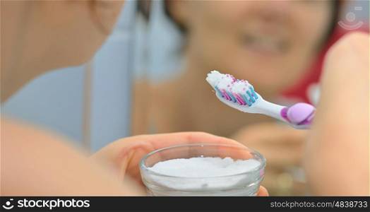 Woman brightening teeth with sodium bicarbonate