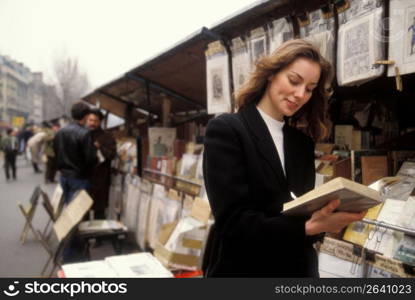 Woman browsing at bookstand, Paris, France