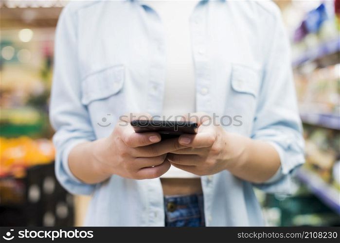woman browsing smartphone grocery store