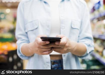 woman browsing smartphone grocery store