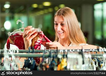 Woman browsing through clothes on a rack in a fashion store