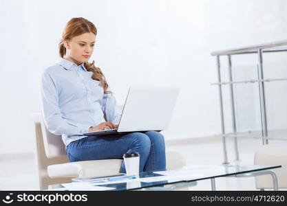 Woman browsing web. Young pretty businesswoman sitting and using laptop