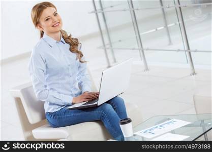 Woman browsing web. Young pretty businesswoman sitting and using laptop