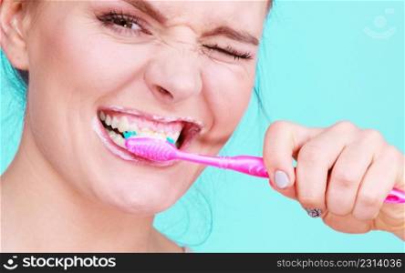 Woman brushing cleaning teeth. Girl with toothbrush close up. Oral hygiene. Blue green background. Woman brushing cleaning teeth