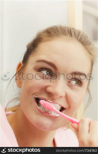 Woman brushing cleaning teeth. Girl with toothbrush in bathroom. Oral hygiene.. Woman brushing cleaning teeth in bathroom