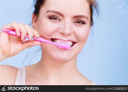 Woman brushing cleaning teeth. Girl with toothbrush. Oral hygiene. Blue background. Woman brushing cleaning teeth