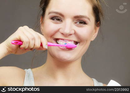 Woman brushing cleaning teeth. Girl with toothbrush. Oral hygiene. Dark background. Woman brushing cleaning teeth