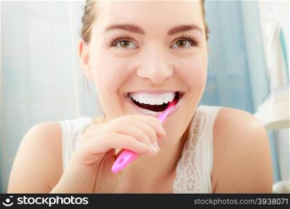 Woman brushing cleaning teeth. Oral hygiene.. Young woman brushing cleaning teeth. Girl with toothbrush in bathroom. Oral hygiene.