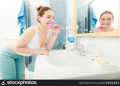 Woman brushing cleaning teeth. Oral hygiene.. Young woman brushing cleaning teeth. Girl with toothbrush in bathroom. Oral hygiene.