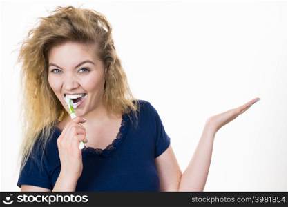 Woman brushing cleaning teeth. Positive girl with toothbrush holding open hand copy space for product. Oral hygiene.. Woman brushing teeth holds open hand