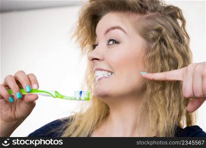 Woman brushing cleaning teeth. Positive girl with toothbrush. Oral hygiene. Studio shot on white background. Woman brushing cleaning teeth