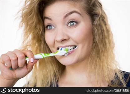 Woman brushing cleaning teeth. Positive girl with toothbrush. Oral hygiene. Studio shot on white background. Woman brushing cleaning teeth