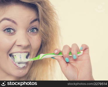 Woman brushing cleaning teeth. Positive girl with toothbrush. Oral hygiene. Toned image. Woman brushing cleaning teeth