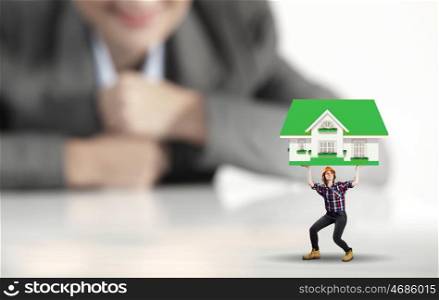 Woman builder. Businesswoman looking at miniature of woman builder holding model house