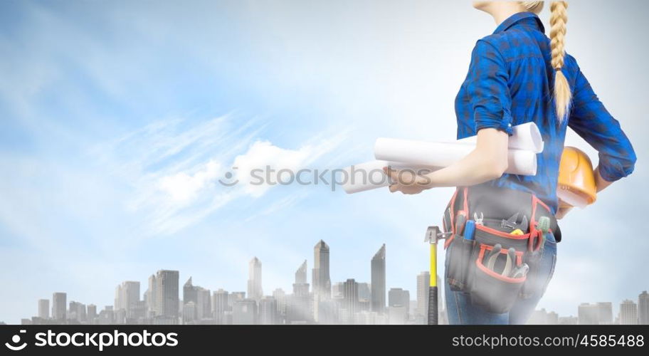 Woman builder. Close up of woman builder with hardhat and papers in hands