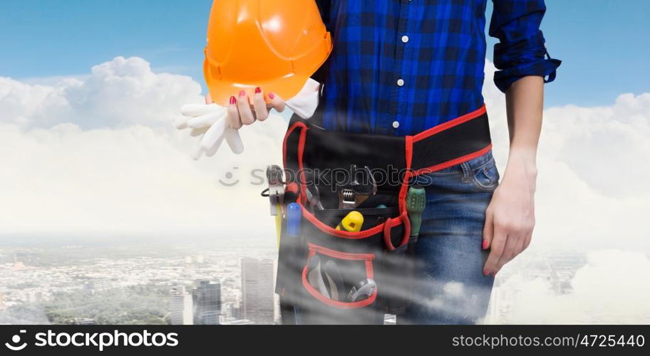 Woman builder. Close up of woman builder with hardhat in hands