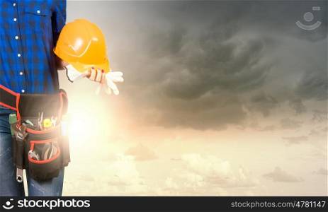 Woman builder. Close up of woman builder with hardhat in hands