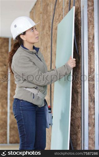 woman builder fixing the wall