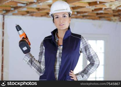 woman builder holding a drill
